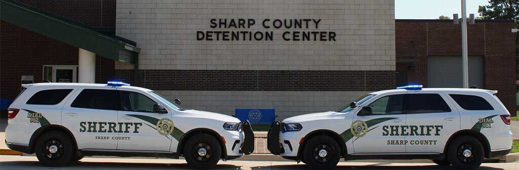 Two Sharp County Sheriff Patrol Durangos facing each other in front of the Detention Center.